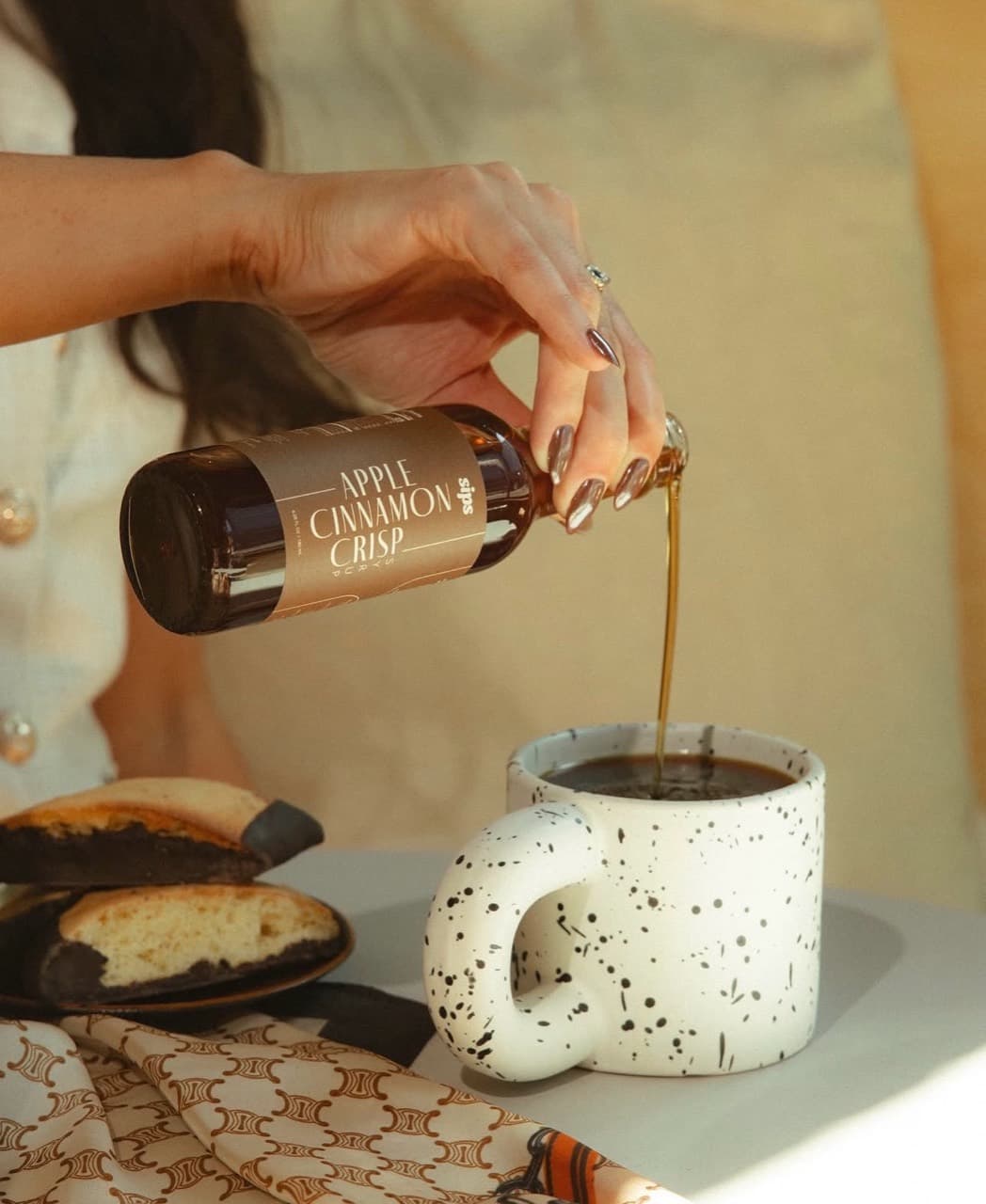 Coffee poured into a speckled mug beside pastries