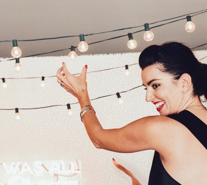 Woman at a Founder Dinners gathering beneath string lights